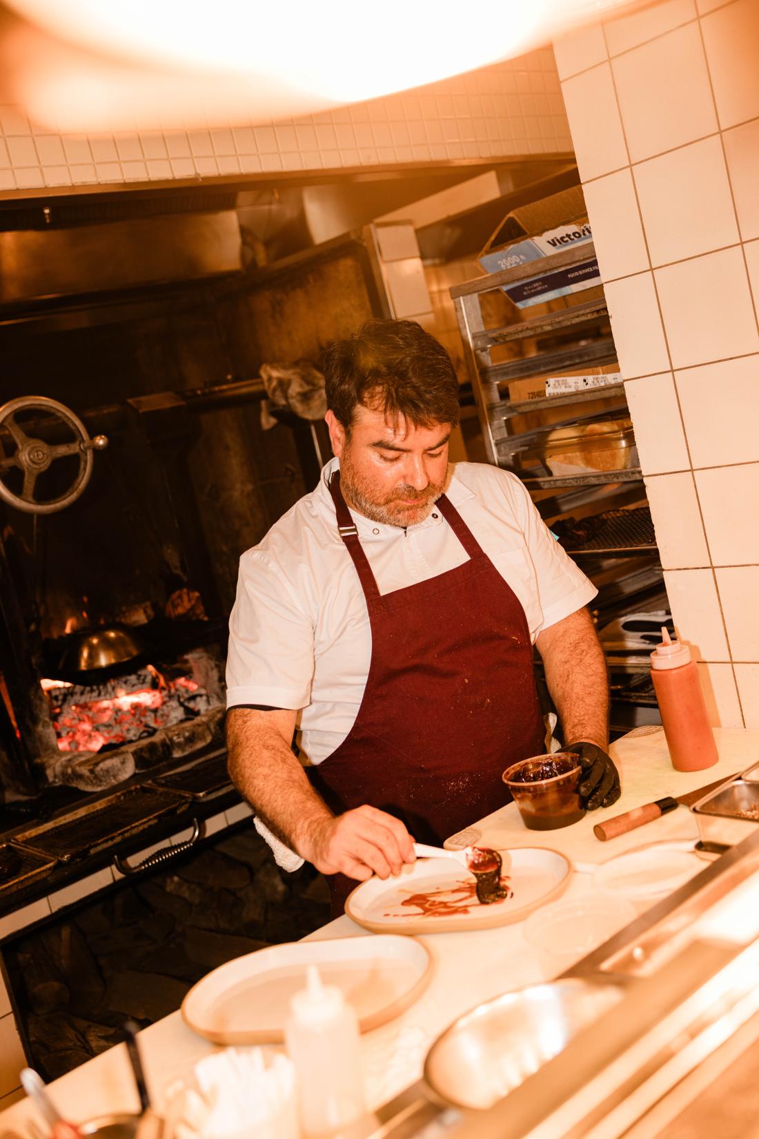 A chef working at the wood-fired oven