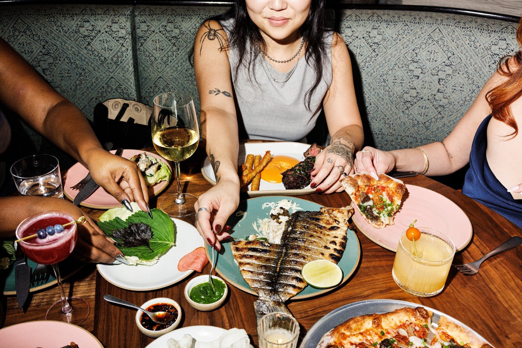 Guests sharing family-style dishes and cocktails at Gable